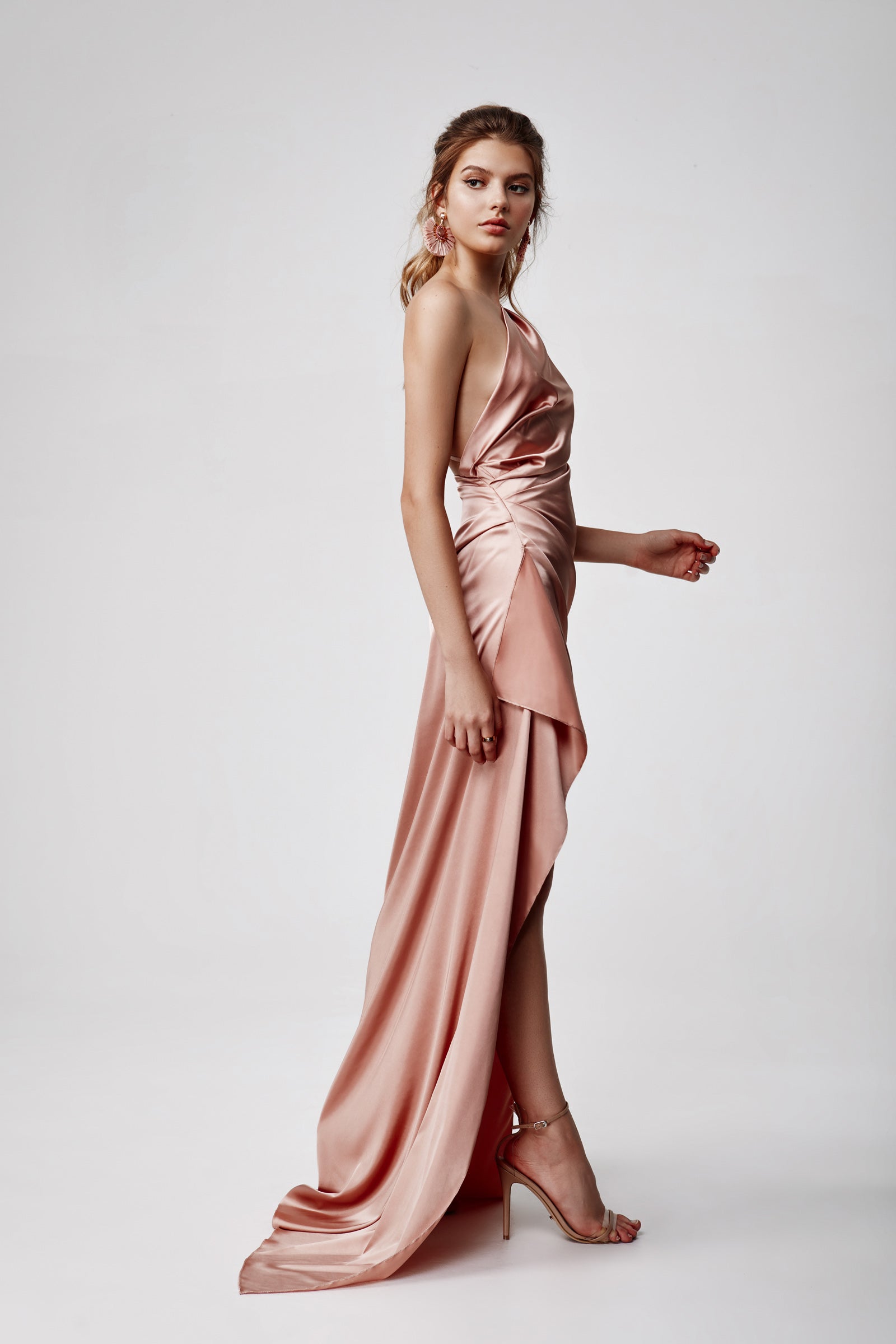 Samira Dress features a draped backless design with a high split in luxurious pink satin for formal occasions